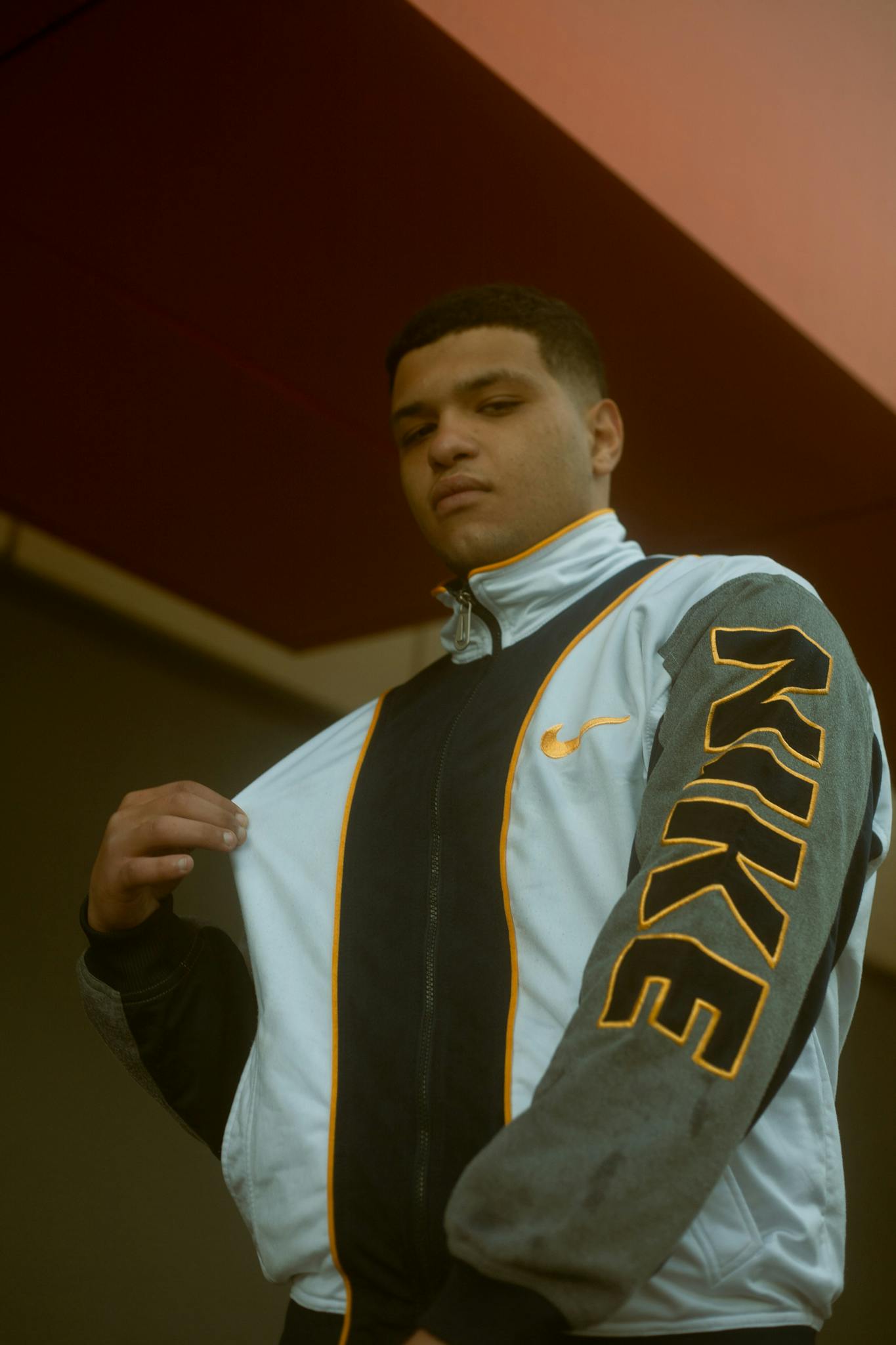Fashion portrait of a teenager in a Nike jacket, posing confidently on a sunny day in Morocco.